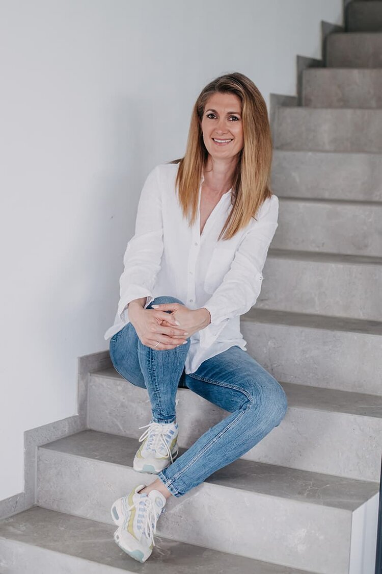 Coaching Waiblingen- Andrea Schweikardt sitzt auf einer Treppe mit angewinkeltem Knie